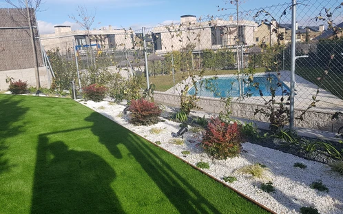 Perfil delimitando césped y una franja de plantas con grava