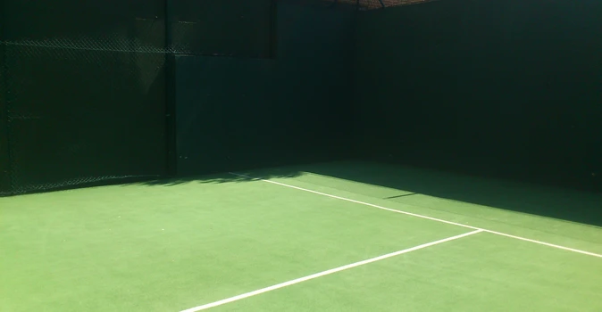 Detalle de las líneas de una pista de pádel con césped verde