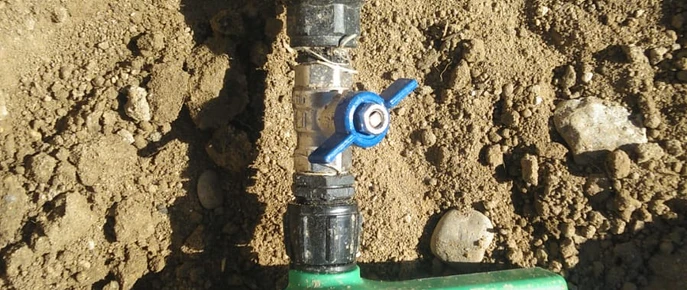 Tubería y llave de paso descubiertas en una zanja