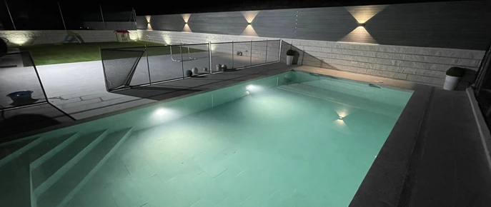 Piscina exterior con iluminación nocturna
