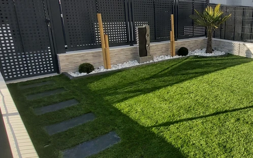 Borde de pizarra delimitando un parterre junto a un camino de losetas