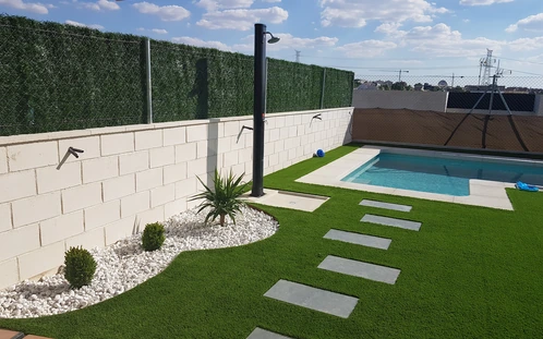 Losetas sobre césped conectando con una piscina